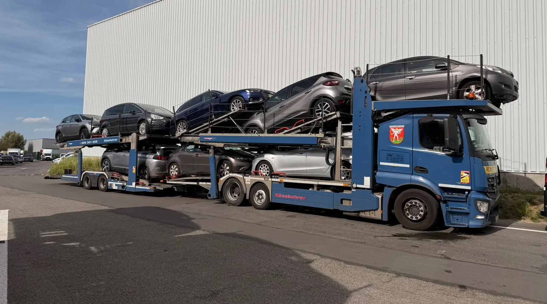 Załadowany transporter ZGODWIAR stojący przy hali, samochody na obu poziomach.