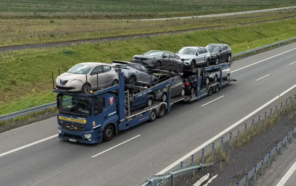 Transporter ZGODWIAR z siedmioma samochodami na trasie szybkiego ruchu.