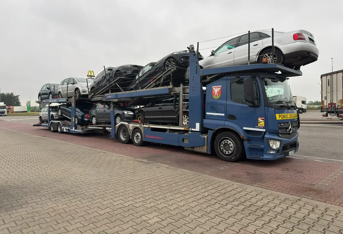 Transporter ZGODWIAR załadowany samochodami, widziany z boku.